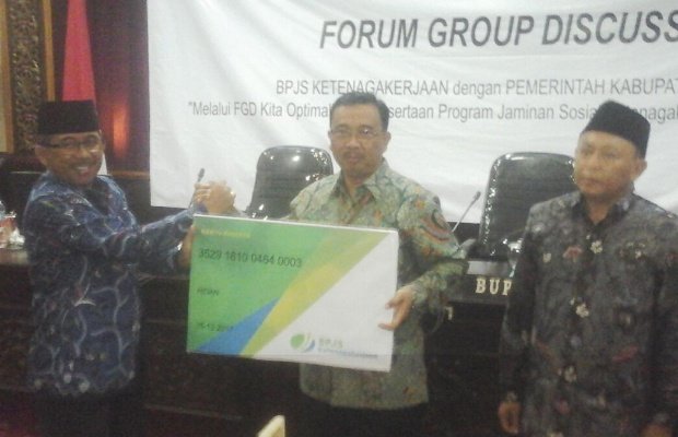 Foto: Bupati Sumenep A Busyro Karim saat menyaksikan Kepala dinas Pertanian Sumenep Bambang Hariyanto, melakukan serah terima kartu tani dengan BPJS 