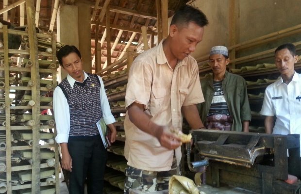 Foto: salah seorang pengrajin genteng sumenep sedang memperagakan usaha pembuatan genteng