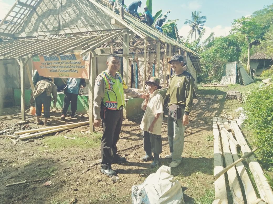 Foto: Aiptu Gunawan saat ikut membantu rehab rumah milik warga