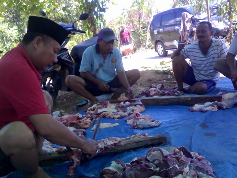 Foto: sejumlah warga saat memotong dan membagi daging sapi