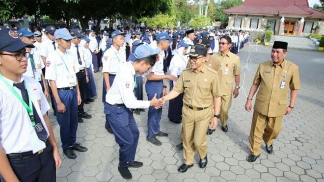 Foto: Bupati Banyuwangi Abdullah Azwar Anas saat menyalami siswa dihari pertama masuk sekolah
