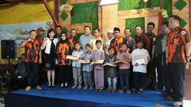 foto: Ketua MPC PP Kota Batu (kiri) didampingi para anggota PP dan tamu undangan saat sesi foto bersama anak yatim piatu usai membagikan santunan