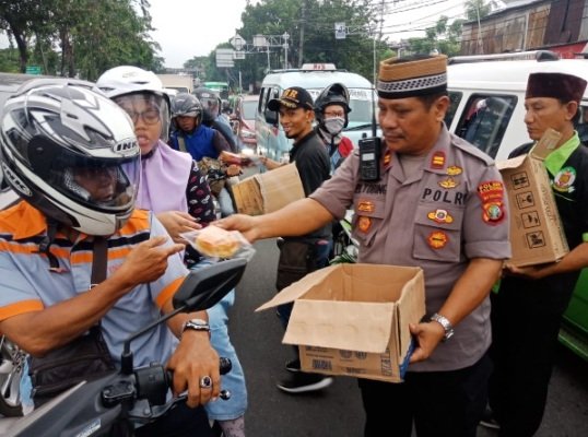Foto: Kapolsek Kalideres AKP Indra Maulana Sahputra sedang bagi-bagi takjil