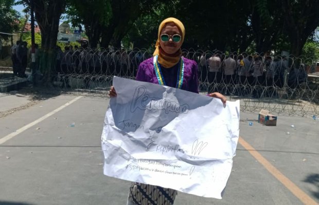 Foto: Lina Wakiah menunjukkan poster tuntunan aksi demonstrasi