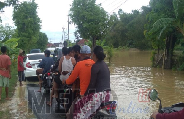 Foto : Warga mengatur lalu lintas saat banjir di jalan raya Kamoning Sampang