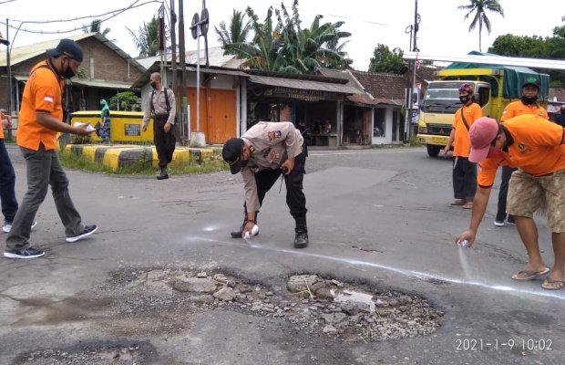 Foto: Kapolsek Mayang dan Ketua Orari. Pengecatan sebagai tanda jalan yang berlubang.