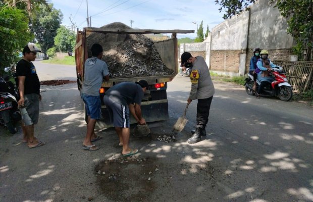  Foto : Jajaran anggota Polsek sumbersari, menutup sejumlah titik ruas jalan yang sudah berlubang.
