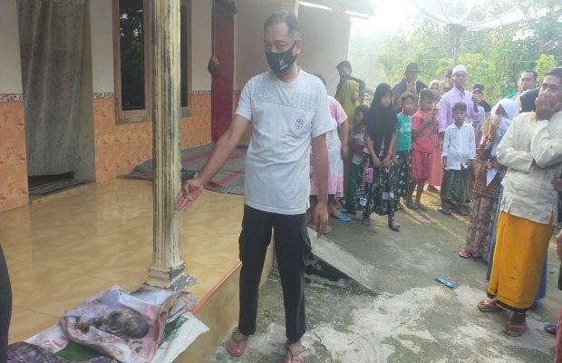 Foto: Petugas menunjukkan mayat bayi perempuan yang sudah dievakuasi ke rumah warga