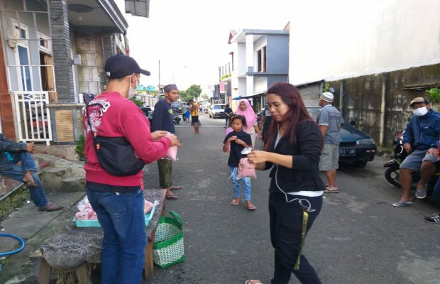 Foto: Salah satu karyawan Inayah Jaya, saat membagikan takjil gratis kepada warga 