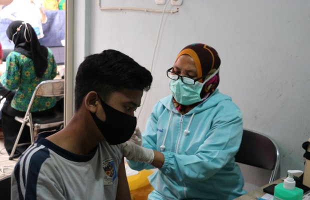  Foto: Petugas dari Dinkes Pemkot Batu, saat memberikan vaksinasi Covid-19 kepada pedagang sayur.