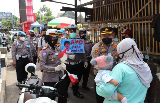 Foto: Kapolres Batu AKBP Catur Cahyono Wibowo, SIK, MH bersama jajarannya saat membagikan masker gratis kepada para pengunjung Pasar Besar Kota Batu.