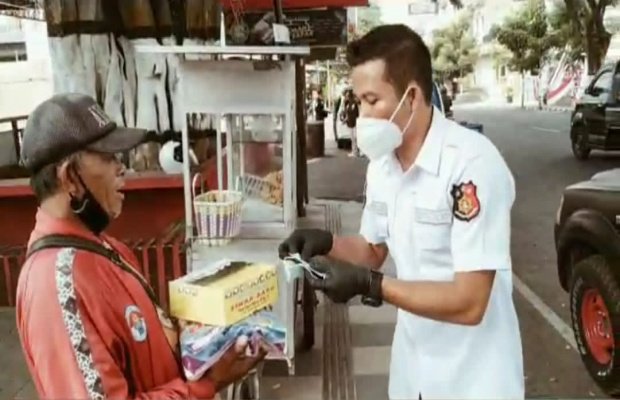 Foto : Kasatreskrim Polres Batu AKP Jeifson Sitorus, SH, SIK, MH, saat membagikan sembako dan masker kepada masyarakat.
