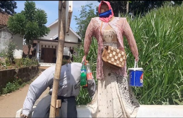 Foto : Warga Kompak Memasang Orang Orangan di Depan Rumah