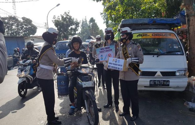  Foto: Kasat Lantas Polres Batu saat membagikan masker secara gratis kepada masyarakat yang ada di Pasar Sayur Kota Batu.