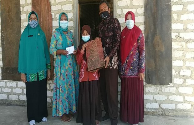 Foto : Kepala Sekolah Saat Serahkan Bantuan dan Seragam Kepada Devi Ayu Safira