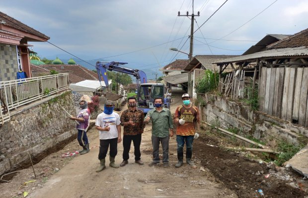 Foto:Kepala Desa Pesanggrahan saat mengecek pelaksanaan pembangunan pelebaran jalan di Dusun Tuyomerto.