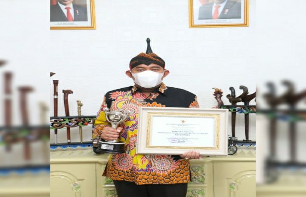 Foto: Bupati Sumenep, Achmad Fauzi, SH. MH. Memegang tropy dan piagam APE