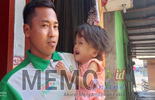 Foto : Alfian sedang mengendong  Emilia Sahra penderita Hidrosefalus
