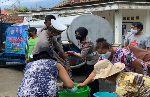 Foto : Kasatlantas Polres Batu bersama jajaran saat membagikan air bersih kepada warga yang terdampak banjir.