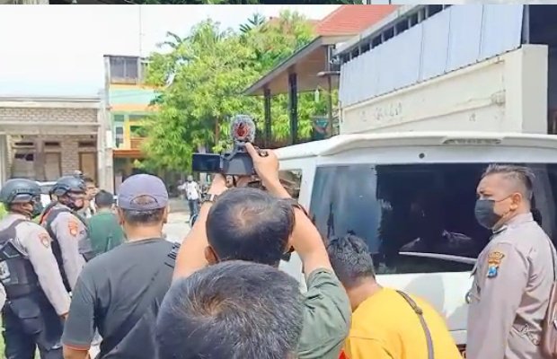 Petugas saat melakukan pengamanan dan mobil yang digunakan untik memuat barang bukti.
