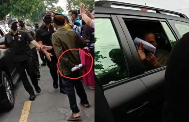 Foto: Pria paruh baya memegang kertas putih yang kemudian dilempar ke Presiden Jokowi