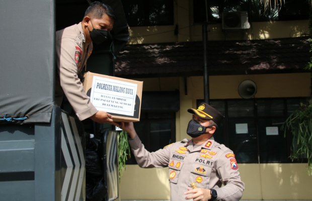 Foto: Kapolresta Malang Kota saat mengumpulkan bantuan paket Sembako ke dalam truk Polisi