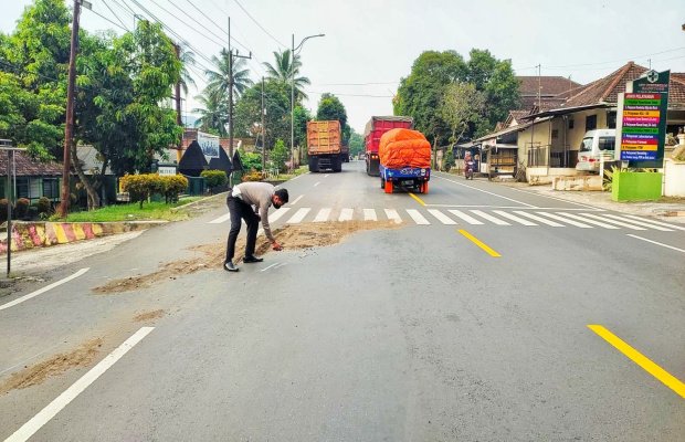 Foto: Petugas Kepolisian saat menutupi ceceran darah korban dengan pasir