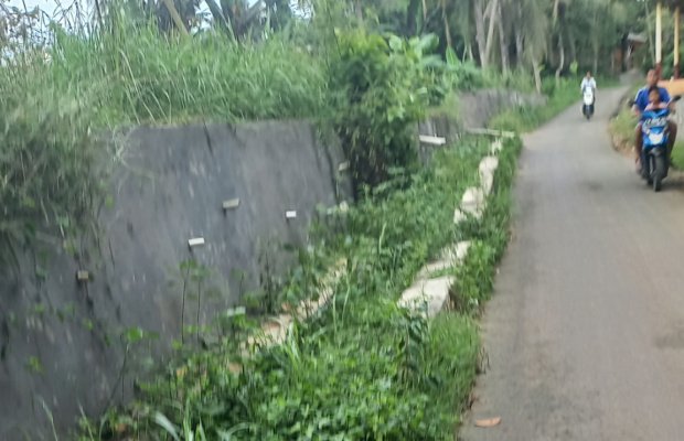 Foto: Salah satu warga saat melintas di dekat proyek TPT yang diduga tidak sesuai sepek. Dan Irigasi itu tersumbat yang diduga akibat pekerjaan proyek TPT.