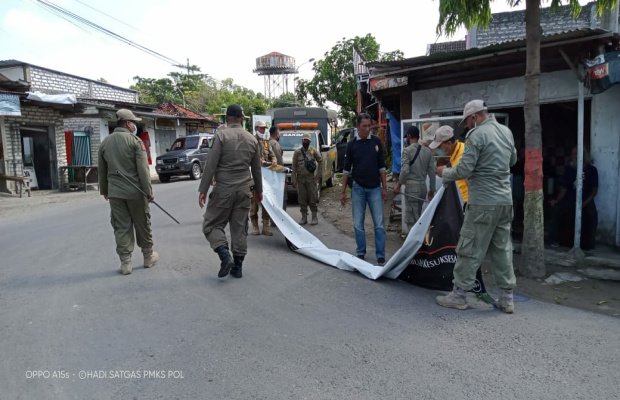 Foto : Anggota Satpol PP Pamekasan saat turunkan Iklan di Jalan Padewau barat, Sabtu 4/6/2022.