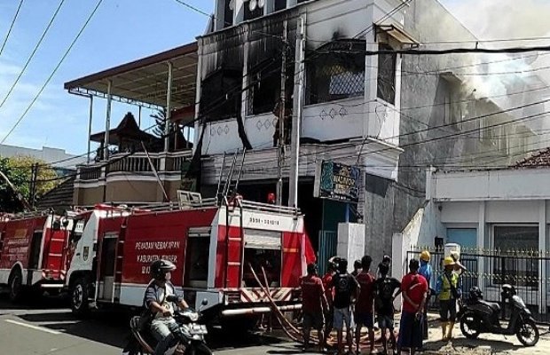 _Foto: Petugas pemadam menjinakkan sisa api pada puing bangunan_