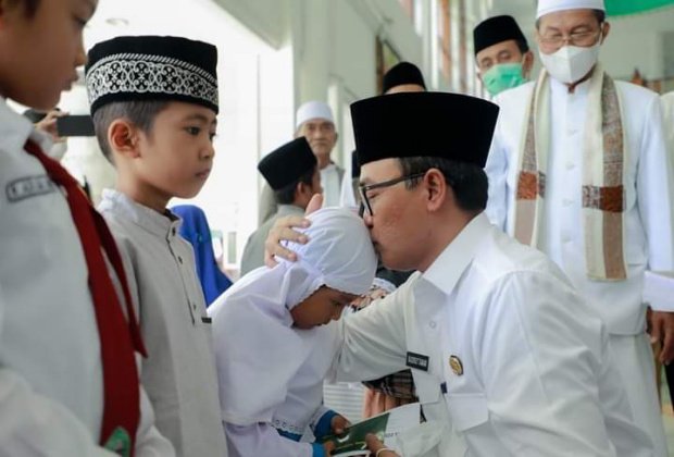Foto : Bupati Pamekasan, Baddrut Tamam saat santuni dan cium kepala anak yatim di Masjid Agung Asy Syuhada' Pamekasan.