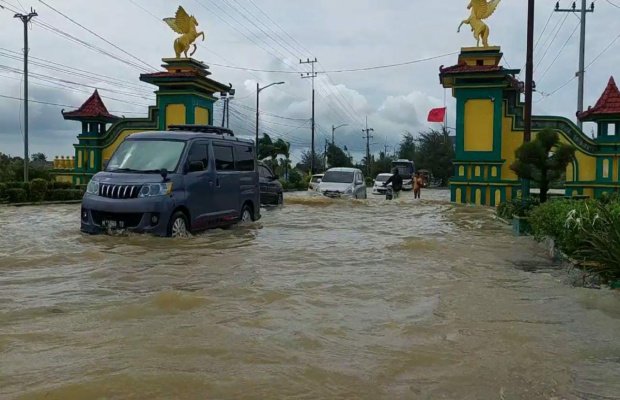 Foto: Sebuah mobil terjebak banjir di jalan raya nasional di Desa Nambakor, Kecamatan Saronggi, Senin (02/1/2023)