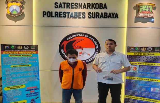 Foto: Tersangka kanan dan petugas di kiri menunjukan barang buktinya
