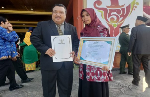 Foto: Kadinsos P3A Sumenep, Achmad Dzulkarnain Bersama Hadariah, Penerima Penghargaan OASE