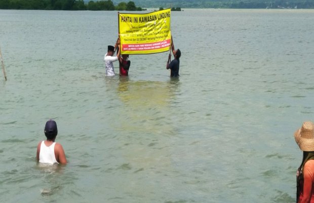 Foto: Warga Gersik Putih saat memasang plakat ditengah laut ber SHM yang disengketakan