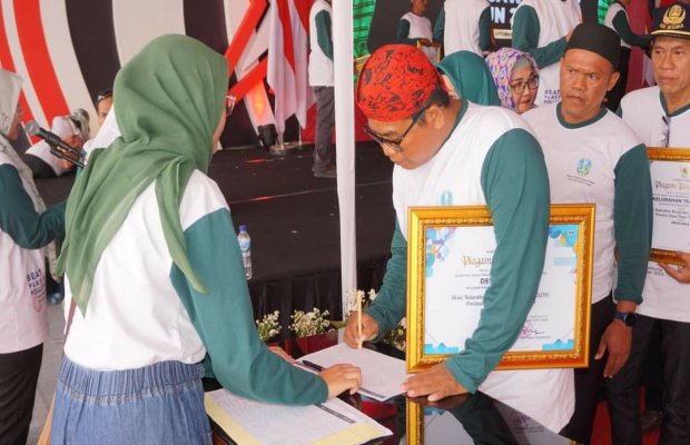 Foto: Kades Lobuk, Moh. Saleh (memakai blangkon) saat menerima penghargaan Desa Berseri dari Gubernur Jawa Timur Khofifiah Indar Parawansa, di Batalyon Armed I Roket, Singosari, Malang.