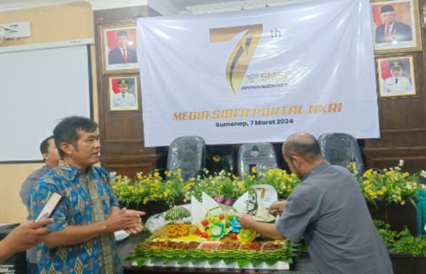 Foto: Ketua SMSI Sumenep saat memberikan potongan tumpeng kepada Kabid Iklan Kominfo