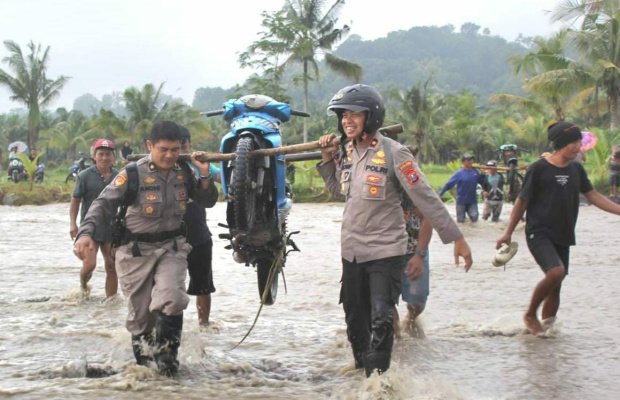Foto : dua anggota Polres Lumajang panggul motor warga