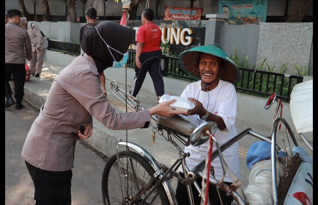 Foto: Anggota Polres Jember saat berbagi kepada abang becak