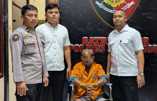 Foto: Tersangka duduk di kursi roda, diapit petugas