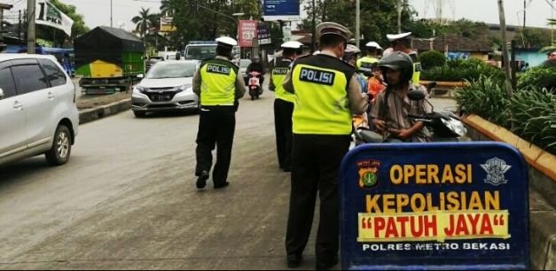 Polisi bersiaga di Jalan R.E. Martadinata, Cikarang Utara, dalam rangka Ops Patuh Jaya, Kamis (26/4/2018).