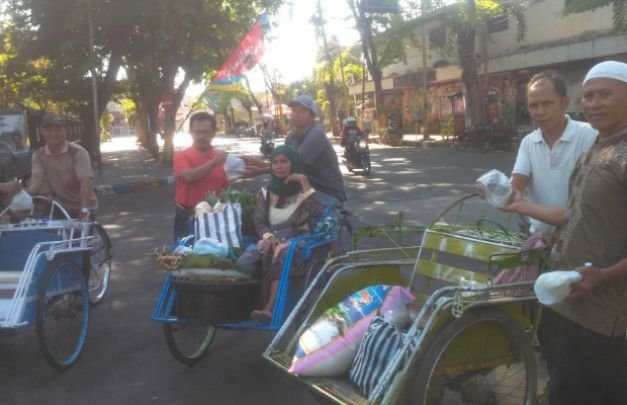 Foto: Komunitas Jumat Sedekah Saat Bagikan Nasi Bungkus Kepada Abang Becak Di Arek Lancor Pamekasan