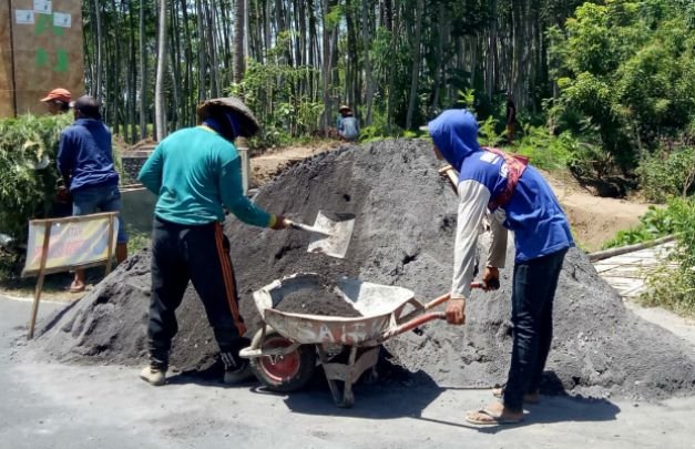 Foto: Pekerja proyek di Desa Tekung salah satunya memakai alas kaki sandal jepit