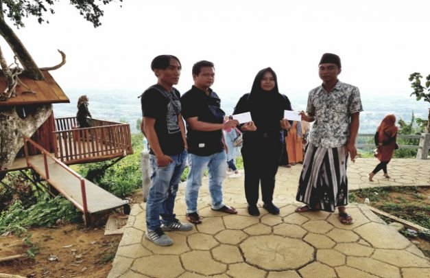 Foto: Kades Tebul Barat di Wisata Puncak Ratu Saat Menyerahkan Bansos Kepada Perwakilan Relawan Untuk Disampaikan Ke Anisa Maharani dan Moh Ali