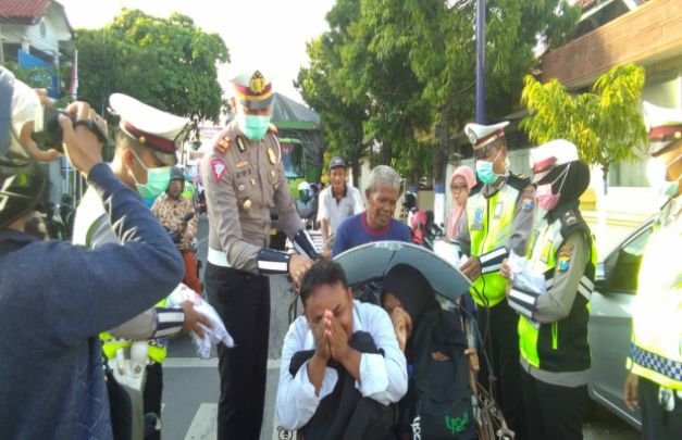 Foto : AKP Ayip Rizal, Kasatlantas Polres Sampang membagikan sembako dan kaos kepada abang becak