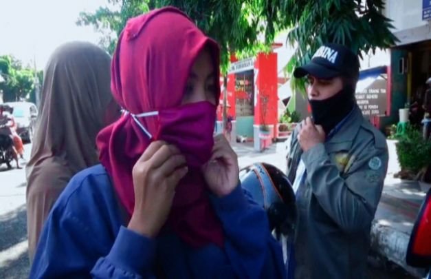 Foto: Salah seorang pengendara motor, mendapatkan edukasi cara memakai masker yang benar