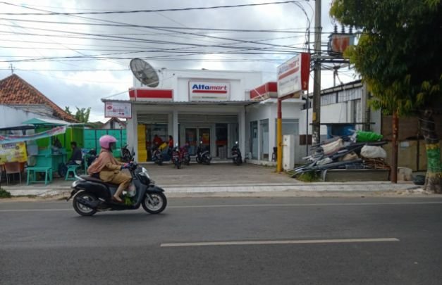 Foto: Seorang pengenda melintas di dpan Alfamart Jalan Hos Cokroaminoto Sumenep.