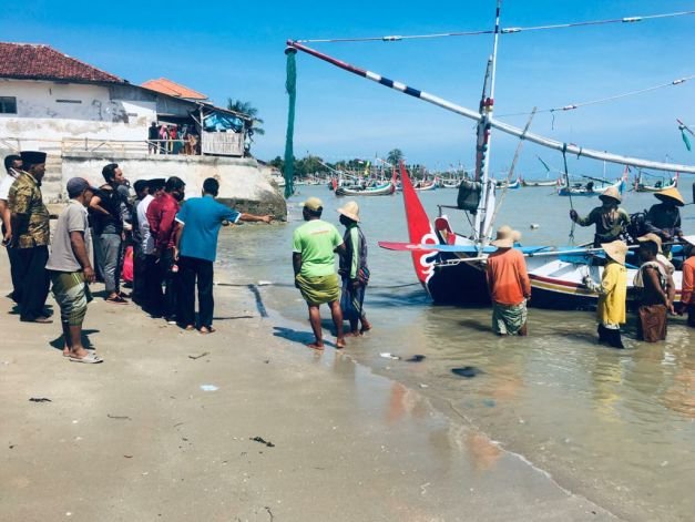 Foto: Sejumlah warga saat menijau perahu di bibir pantai Pademawu Pamekasan