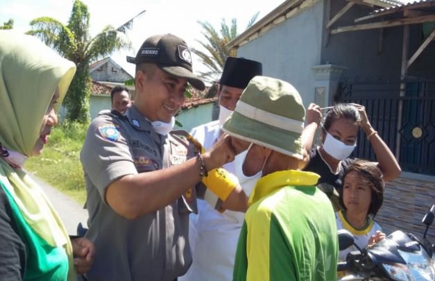 Foto: Polisi Pamekasan saat pasangkan masker kepada warga