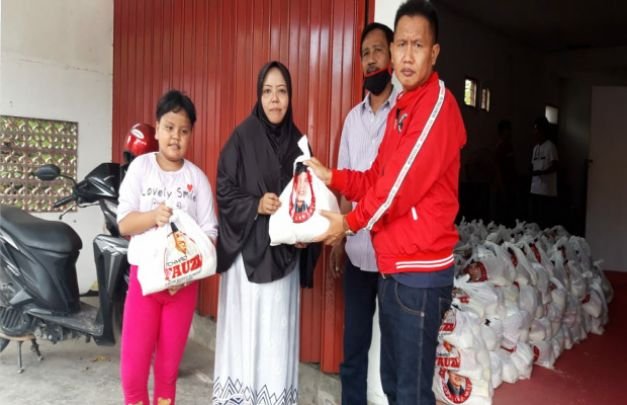Foto : Moch. Nurachmad dan Iwan Effendi membagikan paket sembako kepada masyarakat